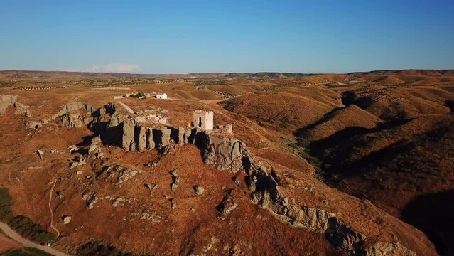 Drone view of the ruins of Castillo de Oreja before a blue skyline