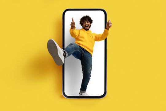 Cool indian guy standing in huge phohe screen, showing like