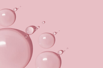 large drops of cosmetic serum, liquid, water, gel on a pink background