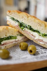 Closeup of two tasty and appetizing sandwiches with some cheese, sausages and lettuce leaves