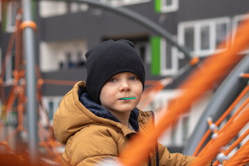 boy preschooler on playground with lollipop