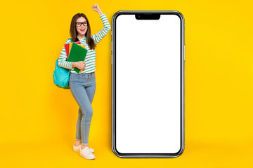 Full size image of charming overjoyed girl near placard promo raise fist in victory pass exam isolated on yellow color background