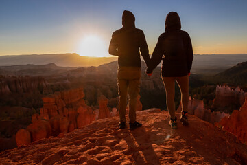 Loving happy couple with panoramic morning sunrise view on sandstone rock formation of Thor hammer...