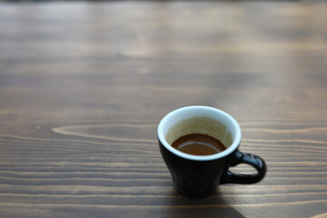 small black coffee cup on wooden table