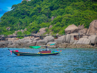 Fototapeta na wymiar Traditional Thai boat in front of Koh Nang Yuan paradise island in Koh Tao, Thailand. Photo from sea from upcoming ship