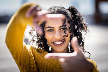Happy black woman portrait framing face with hands and fingers