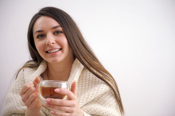 Happy blond woman with bunch hairstyle warming and cover knitted plaid enjoying in her coffee time by the window in cold winter day. Peace of mind and mental health. High quality photo