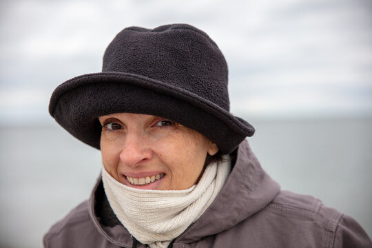 Happy, Active Older Woman At The Beach In Winter. High Quality Photo