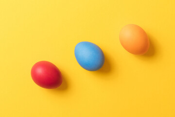 Colorful painted eggs on yellow background. Concept scene. Easter eggs. Selective focus. Top view.