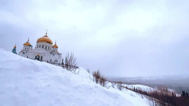 Belogorsky St. Nicholas Orthodox Missionary Monastery. Russia, Perm Krai, Belaya Gora. The temple on the hill in winter. Monastery on the background of snow. 4K