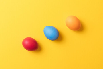Colorful painted eggs on yellow background. Concept scene. Easter eggs. Selective focus. Top view.