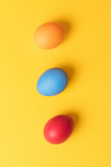 Colorful painted eggs on yellow background. Concept scene. Easter eggs. Selective focus. Top view.
