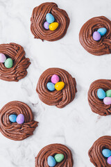 Easter nest cookies. Nest shape cookies with multicolored easter eggs in the center. Easter eggs covered by colorful candy shell.  Baked chocolate nests cookies.