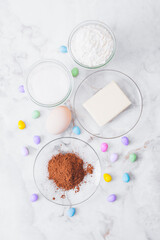 Ingredients for cooking. Eggs, cacao, piece of butter, flour, sugar, colorful candy eggs on table. Ingredients for making dough. Ingredients for baking cookies. Top view.