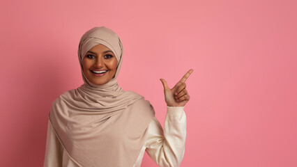 Nice Offer. Smiling Islamic Woman In Hijab Pointing Aside At Copy Space