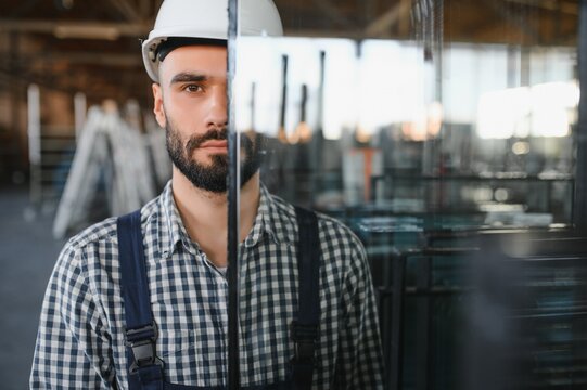 The glazier carries the glass in the glass factory.