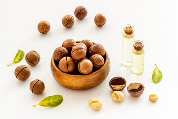 Bottles of macadamia nuts oil with raw nuts. Natural oil for cosmetic or cooking