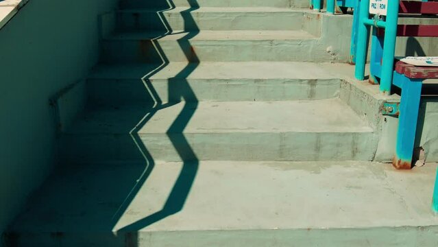 the shadow from the handrails on the concrete steps at the empty stadium