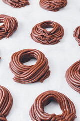 Cacao dough for cookies, dough in the shape of a circle or a nest on parchment paper. Preparing process to baking.