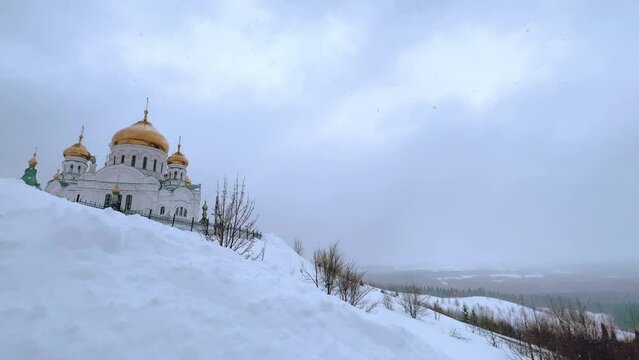 Belogorsky St. Nicholas Orthodox Missionary Monastery. Russia, Perm Krai, Belaya Gora. The temple on the hill in winter. Monastery on the background of snow. 4K