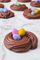 Easter nest cookies. Nest shape cookies with multicolored easter eggs in the center. Easter eggs covered by colorful candy shell.  Baked chocolate nests cookies.