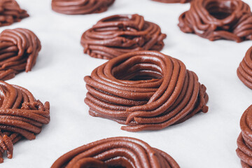 Cacao dough for cookies, dough in the shape of a circle or a nest on parchment paper. Preparing process to baking.