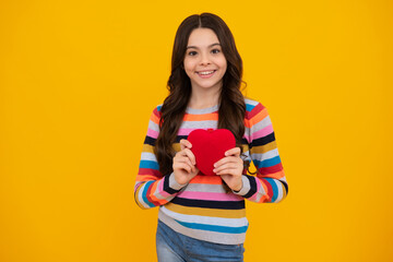 Happy teenager, positive and smiling emotions of teen girl on yellow background. Lovely child girl 12, 13, 14 years old with shape heart love holiday and valentine symbol. Valentine or birthday day.