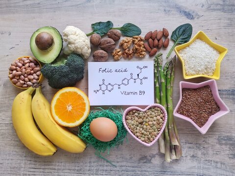 Food rich in folic acid (vitamin B9) with structural chemical formula of folic acid. Natural food sources of vitamin B9. Natural products containing folic acid. Asparagus, avocado, broccoli, nuts, egg