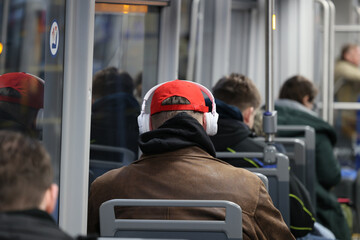 Człowiek w czerwonej czapce jedzie metrem - komunikacja miejska. - obrazy, fototapety, plakaty