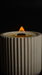a candle in a flowerpot on a black background