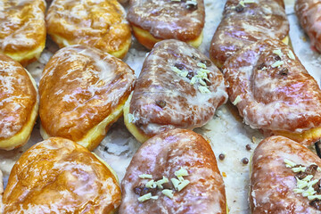 Pączki lukrowane na półce w małej piekarni. 
