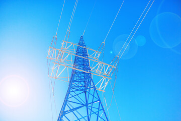 Metal transmission tower with wires against the background of blue sky and sun