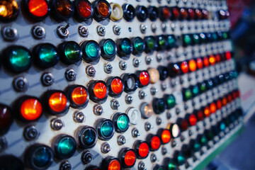Old control panel with many red and green light bulbs and tumblers