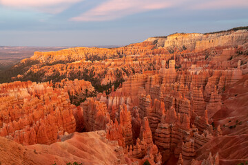 Aerial sunset view of massive hoodoo sandstone rock formation boat mesa in Bryce Canyon National Park, Utah, USA. Last sun rays touching on natural unique amphitheatre sculpted from red rock. Twilight