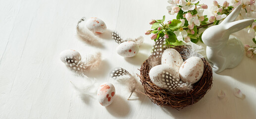 Holiday composition with spring flowers and easter eggs, white bunny on a light background. Happy...