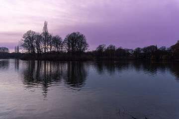Park in the center of Munich, at sunset with the reflection of trees in the water