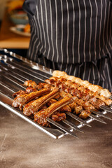 Shish kebab or kebab - pieces of beef, pork or chicken on skewers, cooked on the grill in the hands of the chef. Traditional dish of Caucasian and Asian cuisine