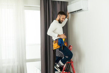 Technician repairing air conditioner on the wall