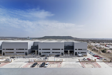 Panoramic image of some industrial buildings in a polygon with many parked cars