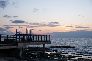 Fototapeta na wymiar Dusk sunset on a dramatic cloudy sky over the Mediterranean sea. Sea with waves
