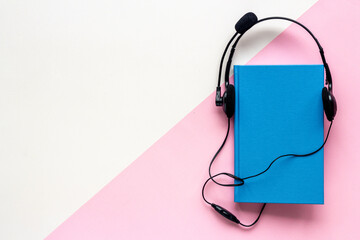 Listen to audiobook concept. Book and headphones nearby