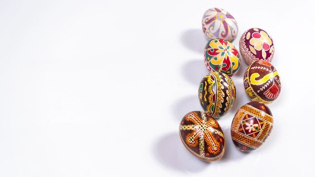 4k Beautiful painted tradition Ukrainian Easter Eggs (Pysanky) appear on a white background. Greeting card. Template for design or text. Stop motion animation. Copy space.