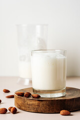 Almond milk in a glass with nuts.