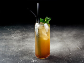 Cold alcoholic or non-alcoholic cocktail with ice on dark background