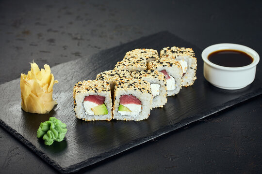 Sushi rolls with tuna and sesame on dark background. Sushi menu. Japanese food.