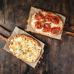 Two Roman-style pizzas with cheese and jamon serrano. Roman square pizza or Pinsa on thick dough,...