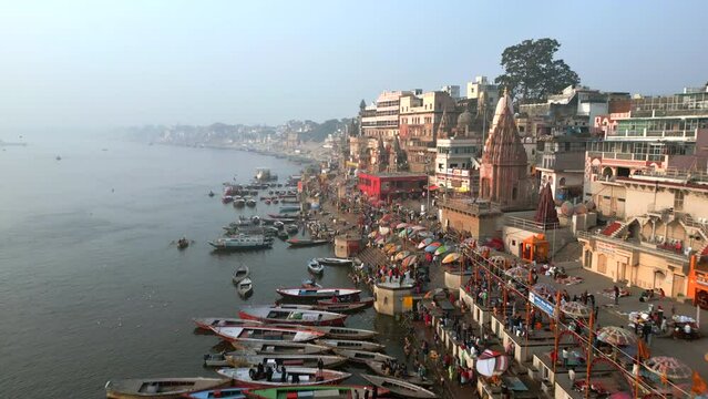 Aerial view flying over the Varanasi ghats on the banks of the sacred Ganges river at sunrise in Varanasi, Uttar Pradesh, India.