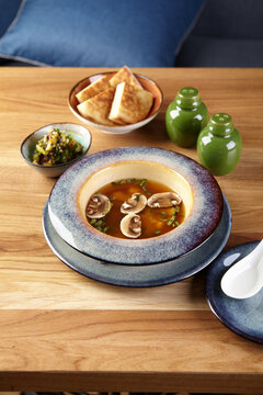 Asian style soup with mushrooms, miso soup in bowl on wooden table