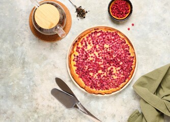 Open pie, shortcrust pastry tart stuffed with cranberries and sour cream filling on a ceramic plate on a gray concrete background. Recipes for pies, tarts.