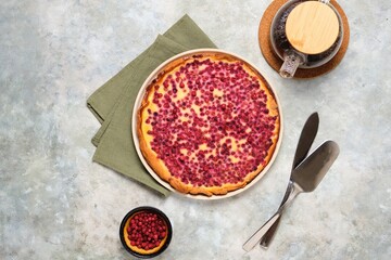 Open pie, shortcrust pastry tart stuffed with cranberries and sour cream filling on a ceramic plate on a gray concrete background. Recipes for pies, tarts.